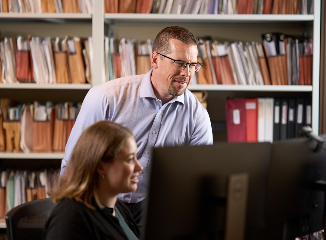 Luke A. Johnson and paralegal reviewing a charity compliance file