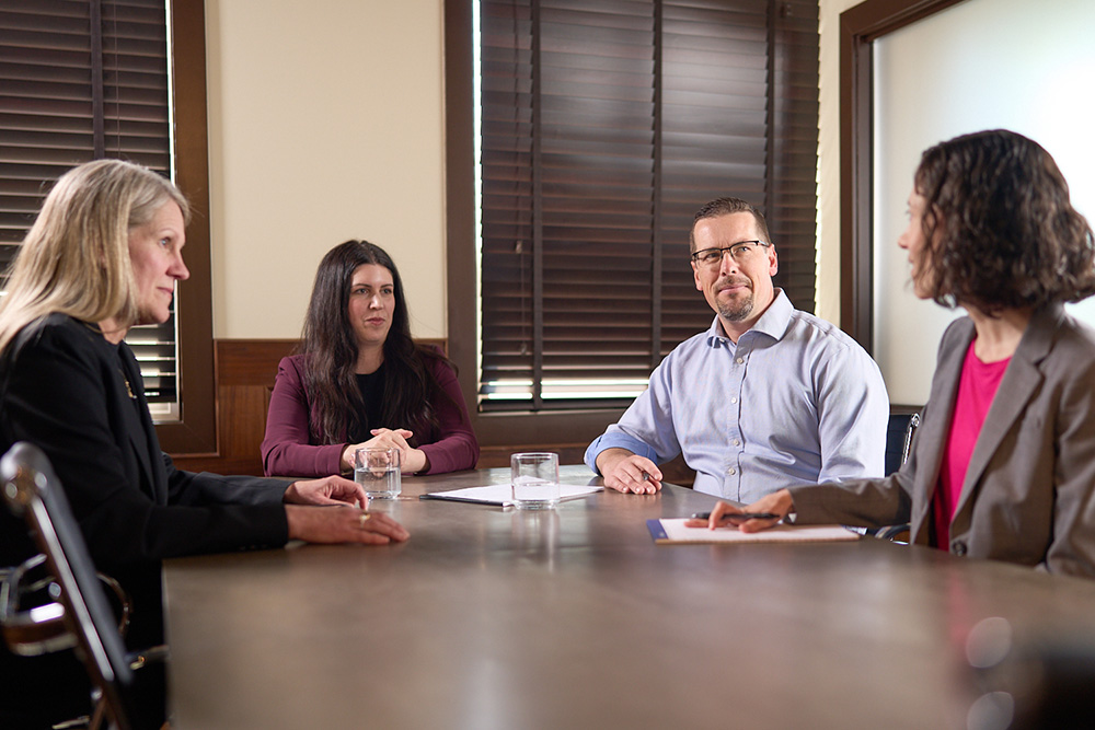 L. Johnson Law Group lawyers meeting with clients in the firm's Surrey boardroom